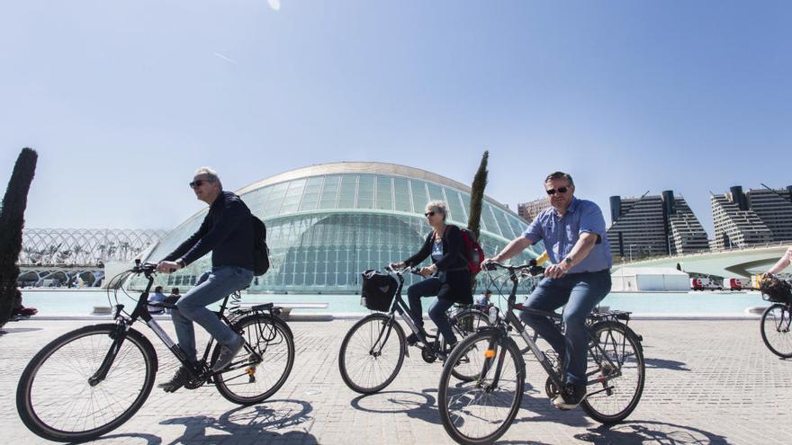 Turistas pasean en bicicleta por la Ciudad de las Artes de València.