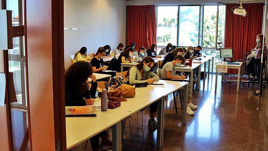 Un grup d&#039;alumnes fa classe en una aula amb les finestres obertes