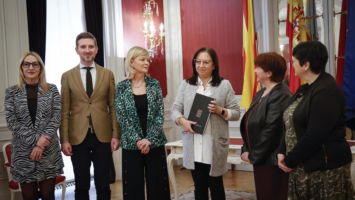 La presidenta de las Corts, Llanos Massó, recibe la memoria de la AVL de manos de su presidenta, Verònica Cantó.