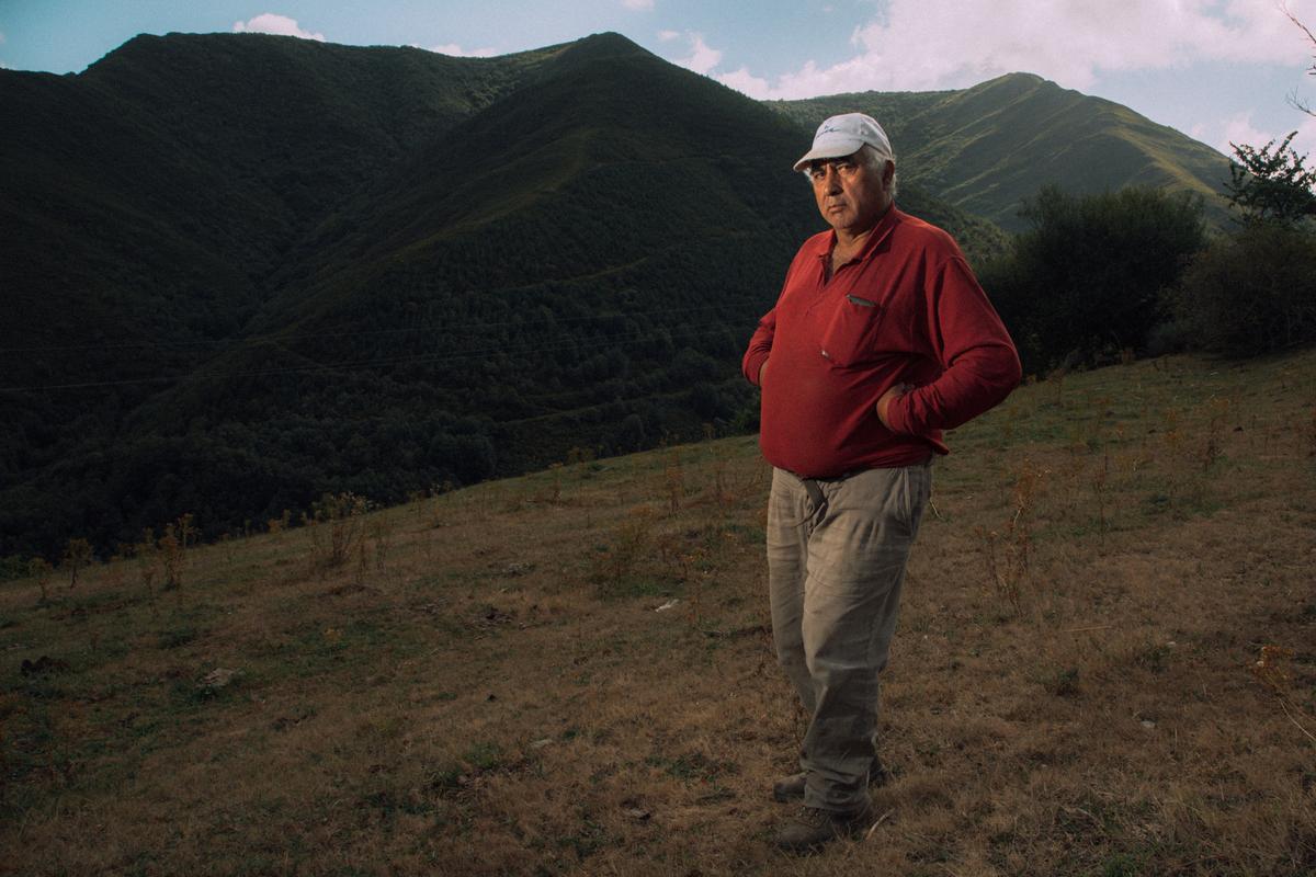 Sergio Cela posa en uno de los prados del pueblo, desde donde se divisa la cordillera leonesa-gallega