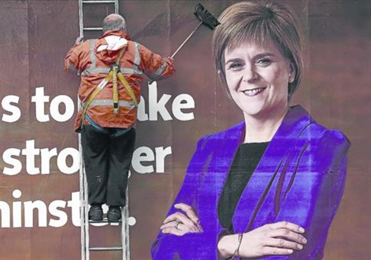 Imatge d’autenticitat 8 Un operari enganxa un cartell electoral de Nicola Sturgeon, líder nacionalista.