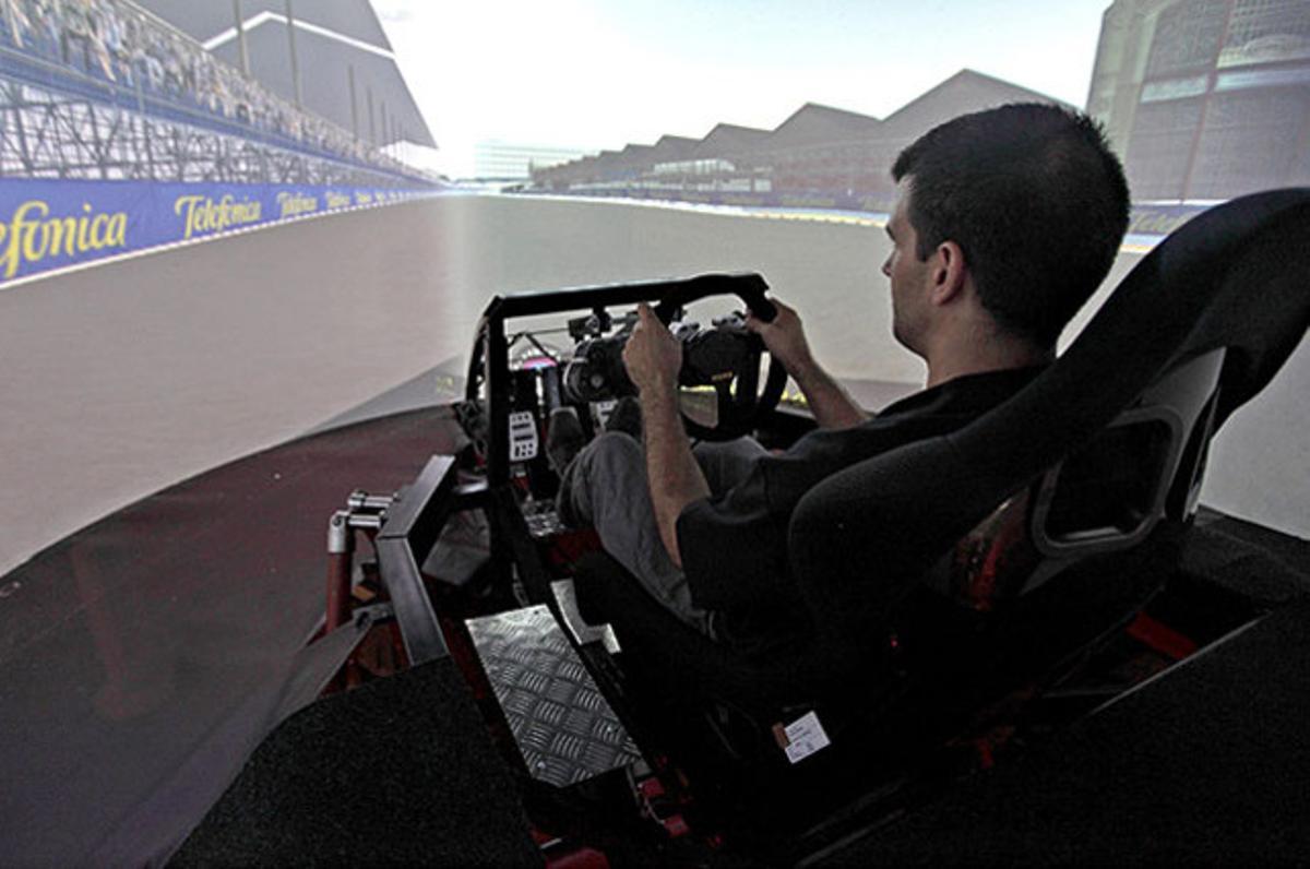 Un home pilota el simulador de conducció de Fórmula-1 i GT que serà utilitzat en la formació de pilots professionals a l’Institut de Robòtica de la Universitat de València.