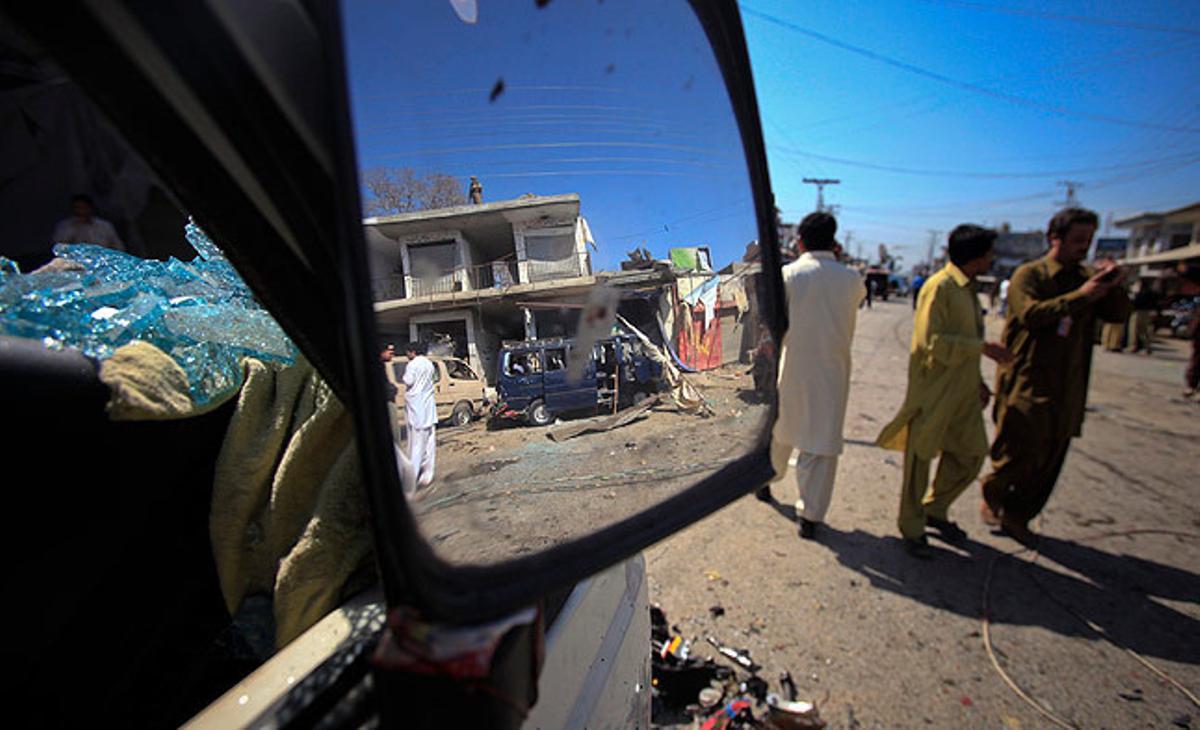 El lloc on s’ha produït un dels atemptats suïcides a Charsadda, al nord del Pakistan, es reflecteix en el retrovisor d’un cotxe destrossat.