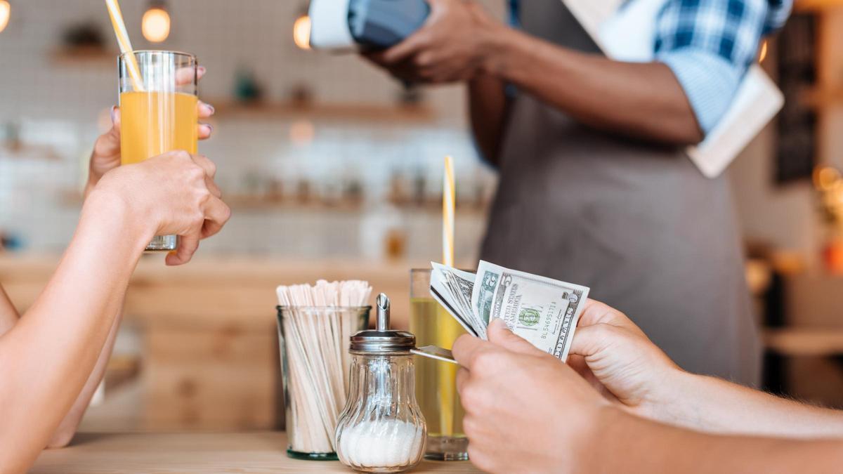 Persona pagando en efectivo en un bar