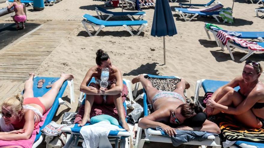 Un grupo de turistas toma el sol en las playas de Benidorm