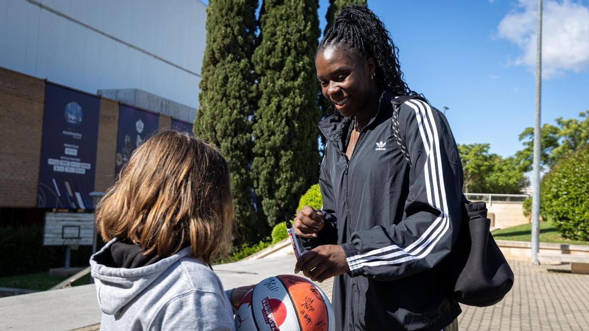 Ornella Bankolé firma el balón a una niña durante el recibimiento de la afición para duelo ante el Valencia.