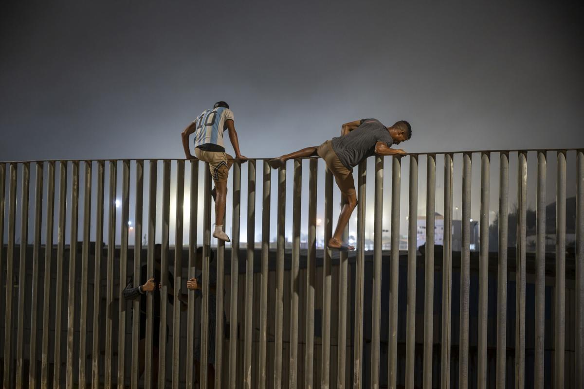 Dos migrantes saltan la valla que hace de frontera entre Ceuta y Marruecos el pasado 31 de julio de 2026.