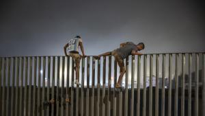 Dos migrantes saltan la valla que hace de frontera entre Ceuta y Marruecos el pasado 31 de julio de 2026.
