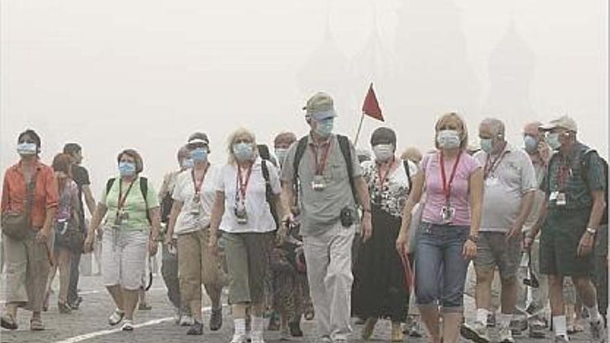 Els turistes que visiten la plaça Roja de Moscou van equipats amb les necessàries màscares.