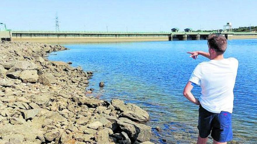 Un joven muestra el bajo nivel del agua del embalse de Nuestra Señora del Agavanzal. | C. G. R.