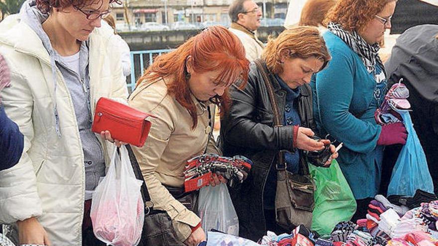 Clientes, en un puesto de la feria de A Xunqueira.  // R. Vázquez