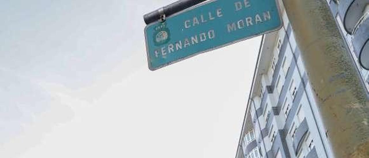 Carlos Rodríguez y María José Hernández, vecinos de la calle Fernando Morán, pasan por debajo de la placa con el nombre del político.