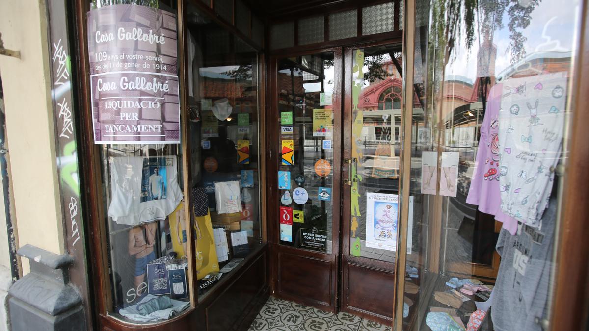 Carteles de despedida y liquidación en la Casa Gallofré de la calle Manso número 68, frente el Mercat de Sant Antoni