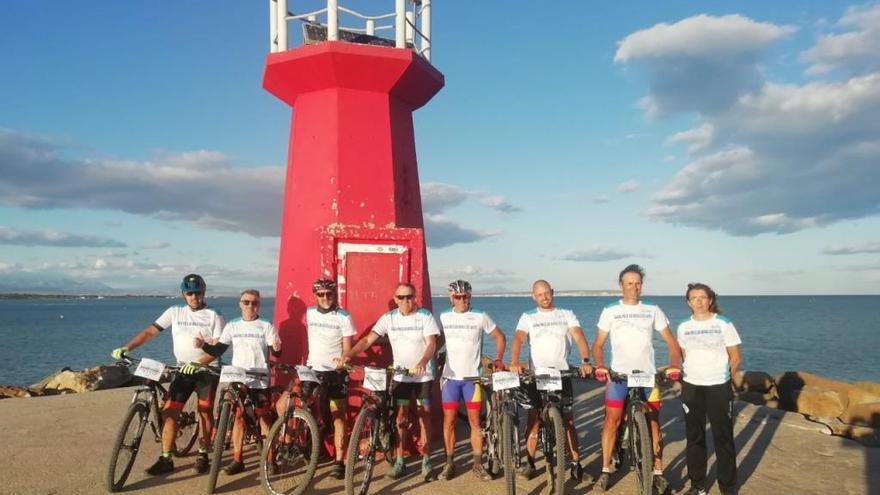 Los participantes posan en el Faro de Guardamar tras terminar la prueba