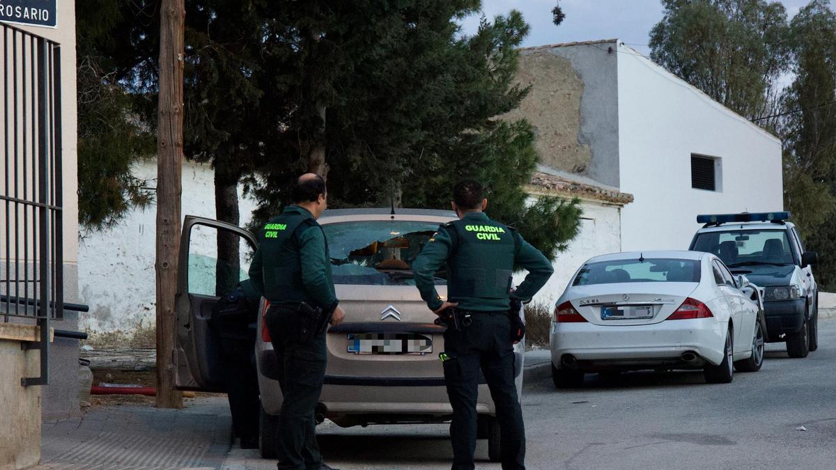 Dos agentes de la Guardia Civil, junto al coche que recibió el tiro en Cañadas de San Pedro.