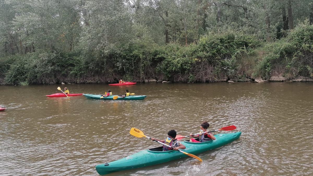 Niños del campamento de Cáritas en sus piraguas.