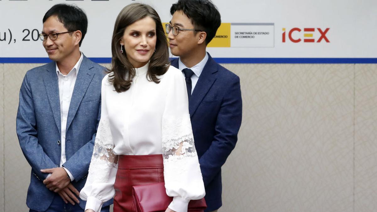 Letizia Ortiz luce espectacular en Seúl con una falda roja de cuero de Hugo Boss y una blusa blanca de Carolina Herrera