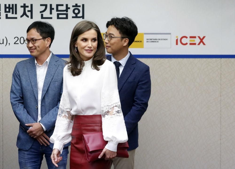 Letizia Ortiz luce espectacular en Seúl con una falda roja de cuero de Hugo Boss y una blusa blanca de Carolina Herrera