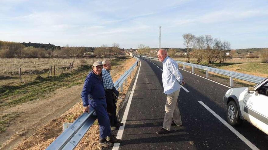 El alcalde de Villanueva de las Peras, Juan García, junto a dos vecinos en el acceso a la localidad.