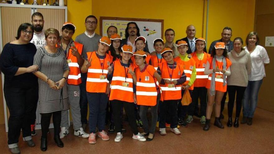 Los niños que recibieron los carnés posan, ayer, con varios profesores y los responsables de Tráfico.