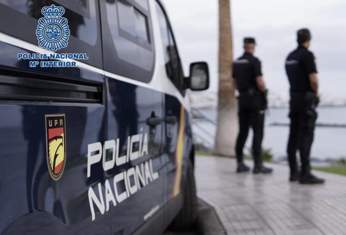 Agentes de la Policía, junto a su coche patrulla.