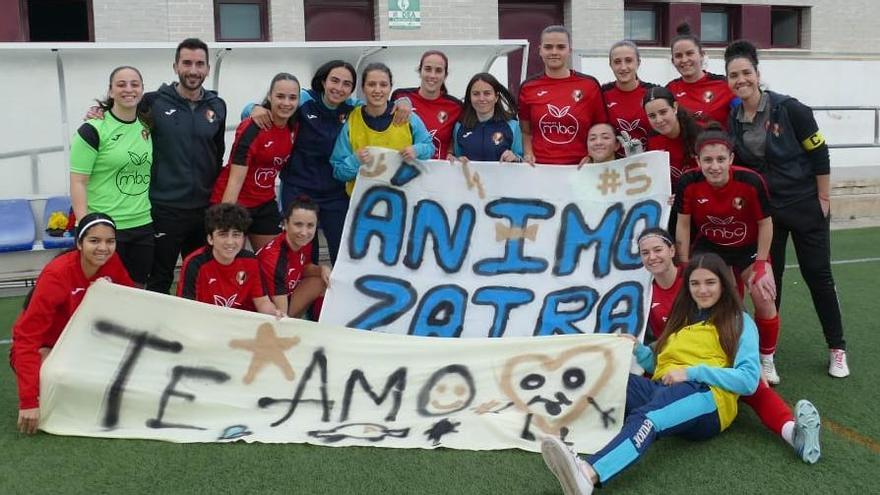 Jugadores y técnicos del CF Miramar con la pancarta de ánimo a la lesionada Zaira