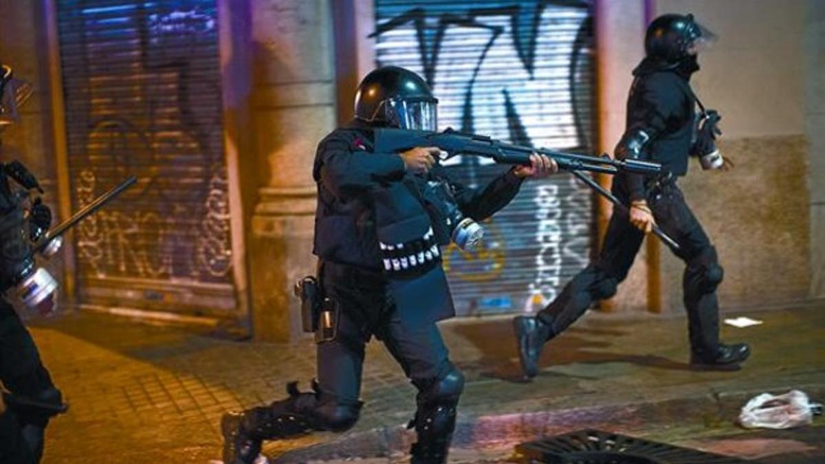 Despliegue 8 Un agente antidisturbios de los Mossos apunta con su arma durante la huelga general del pasado 14 de noviembre en Barcelona.