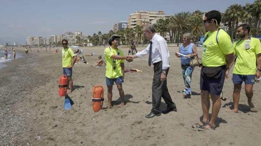 El alcalde de Málaga saluda a varios de los socorristas que atenderán las playas de la capital.