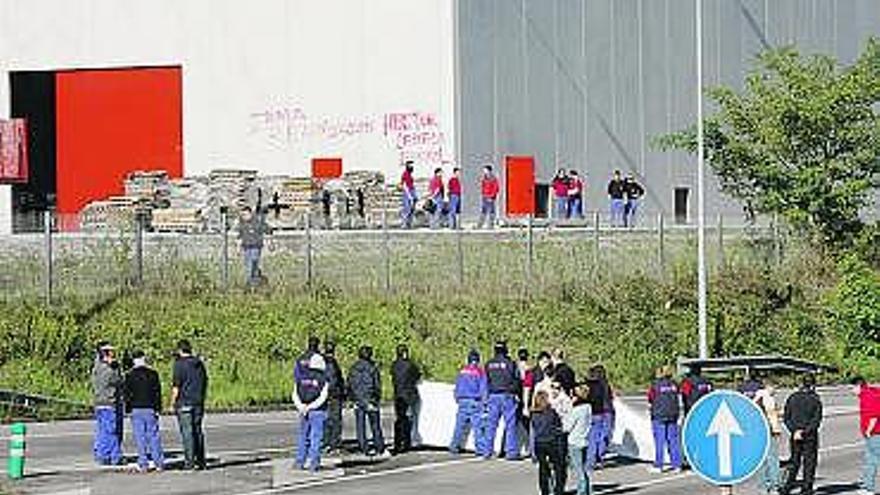 Movilización de los trabajadores de Alas, con la factoría al fondo.