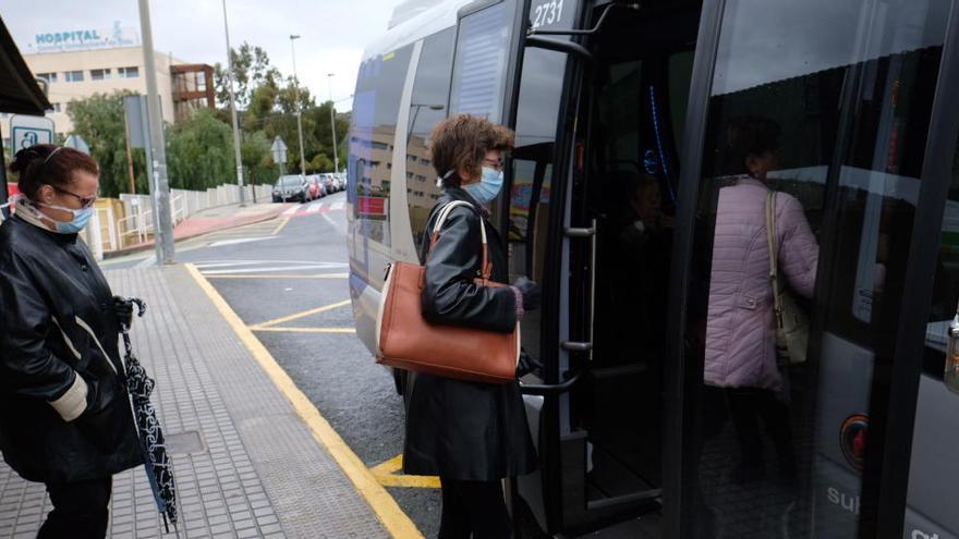 Viajeros tomando el autobús en la parada del Hospital de Elda al principio de la pandemia.