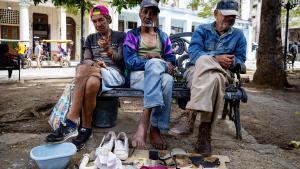 Tres vendedores de baratijas en un parque de La Habana