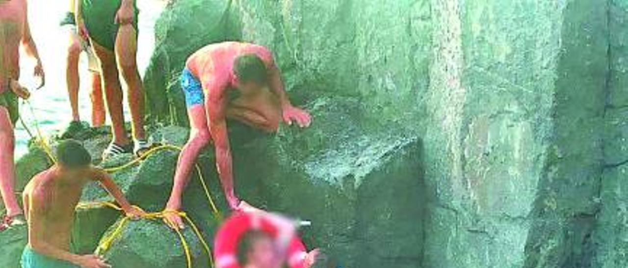 En la parte superior, la foto en la que aparece el policía local de Santiago del Teide Edwin Gorrín salvando a una de las afectadas por el golpe de mar en el Tancón. Debajo, el agente. | el día