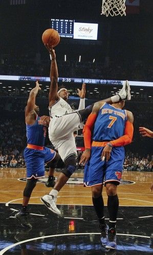 Brooklyn Nets Gerald Wallace comes down atop New York Knicks Carmelo Anthony as he shoots to score in NBA game in New York