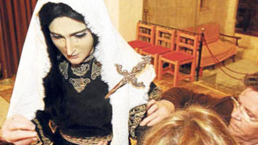 Las camareras de la Virgen le dan los últimos toques a la vestimenta para la Pasión.
