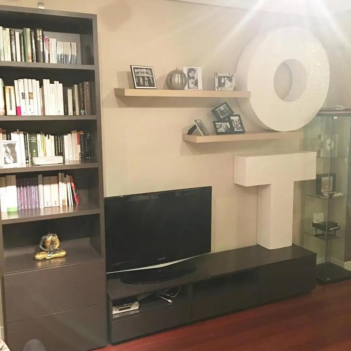 El guiño a su paso por el programa descansa sobre el mueble de la televisión y sobre una repisa superior