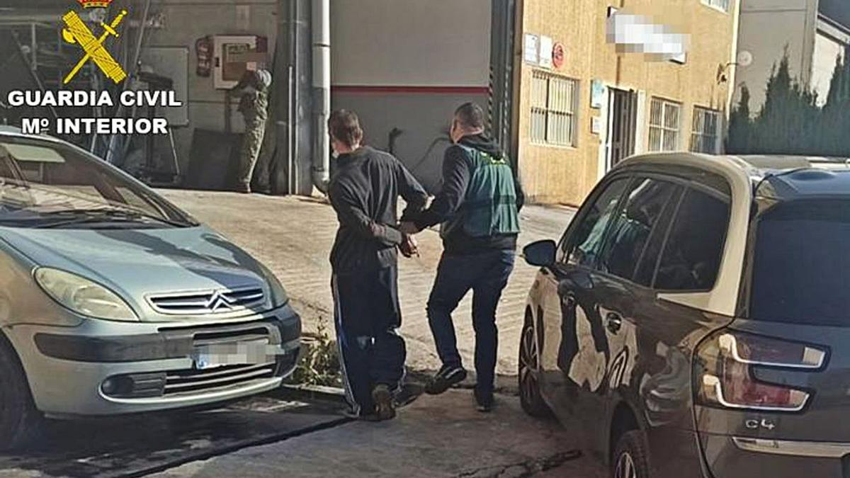 Un agente traslada al detenido por los robos de tapas en Xàbia. | INFORMACIÓN