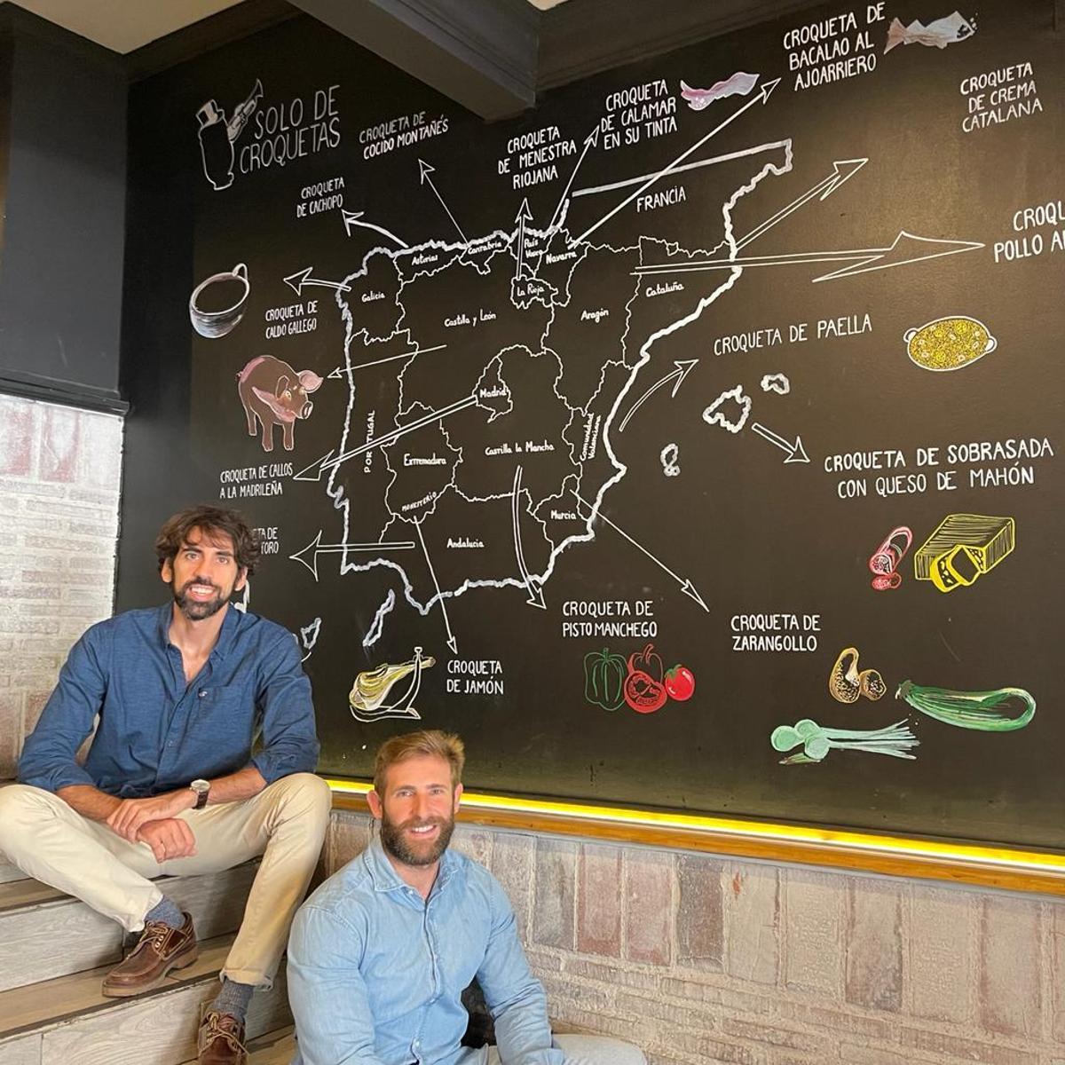 Eduardo Gambero y Javier del Moral, ante el mapa croquetero de España, en su restaurante madrileño.