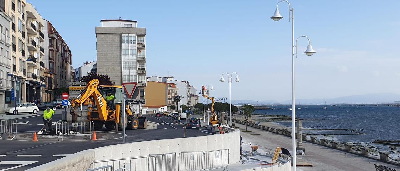 Los trabajos que se llevan a cabo en la rotonda instalada en la confluencia de Beiramar con Castelao, junto a una de las farolas pintadas..