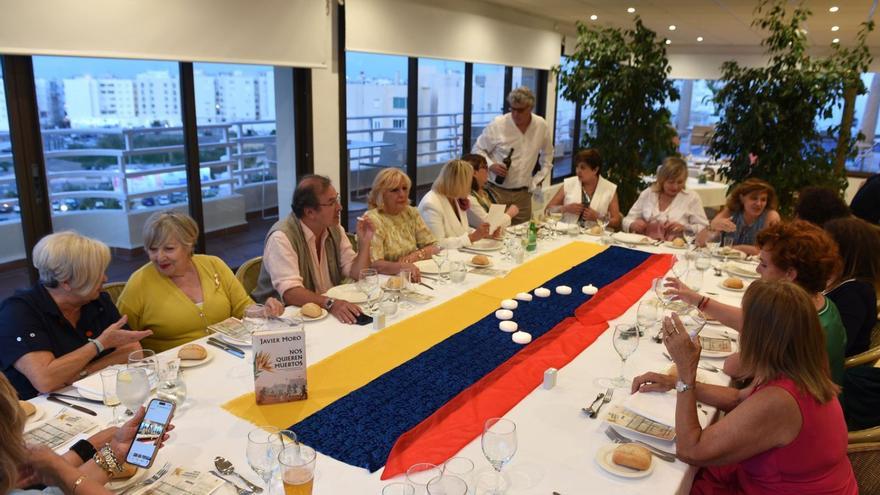 Javier Moro con las asistentes a la sesión del Club de Lectoras, con una bandera venezolana sobre la mesa. | FOTOS DE CARMEN PI