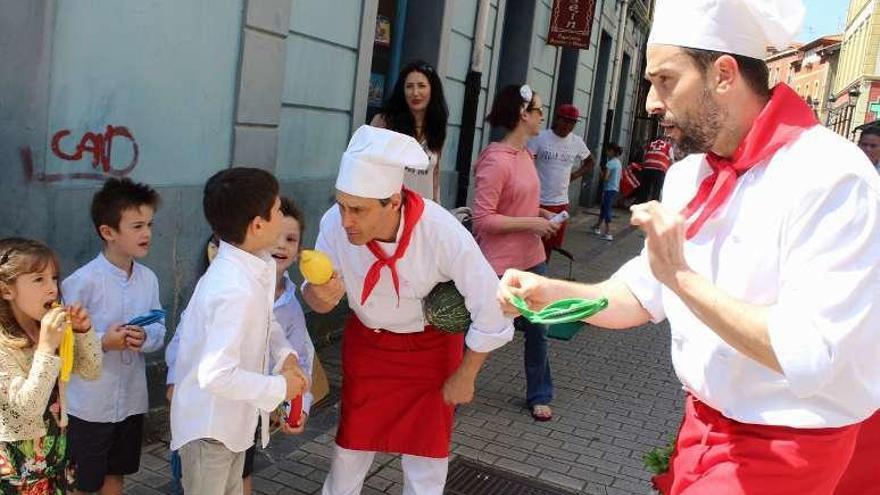 Los &quot;cocineros sandungueros&quot;, ayer, entregando globos a unos niños en el mercado de Candás.