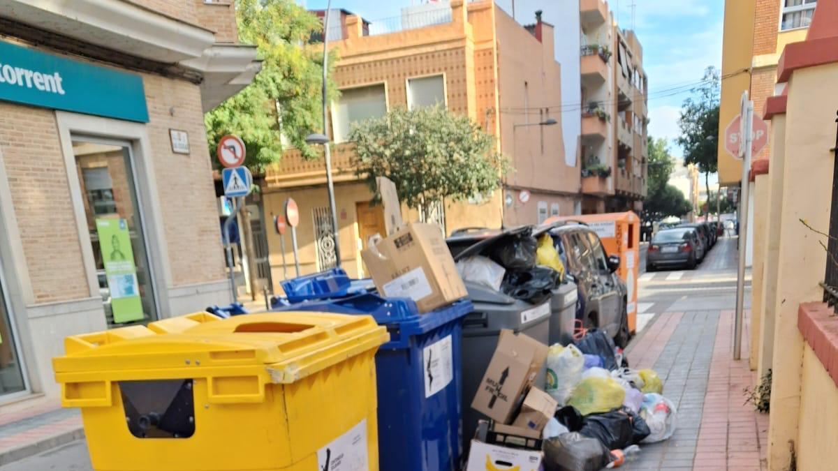 Una calle céntrica de Albal con la basura desbordada de los contenedores.