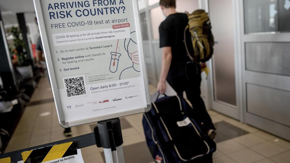 Un cartel informa de los test de coronavirus en el aeropuerto de Schönefeld, en Berlín.