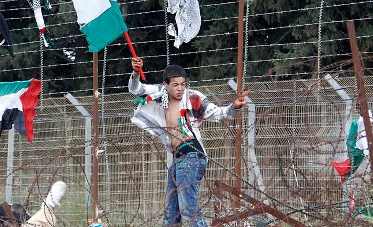 Un jove manifestant palestí ferit fa onejar una bandera durant els enfrontaments entre soldats israelians i activistes palestins a la població libanesa de Marun al-Rass, a prop de la frontera amb Israel. Diumenge, en la commemoració de la Naqba, les forces israelianes van matar 10 persones i en van ferir 112.