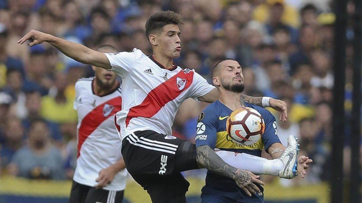 Exequiel Palacios lucha por un balón con el jugador de Boca Juniors Darío Benedetto.