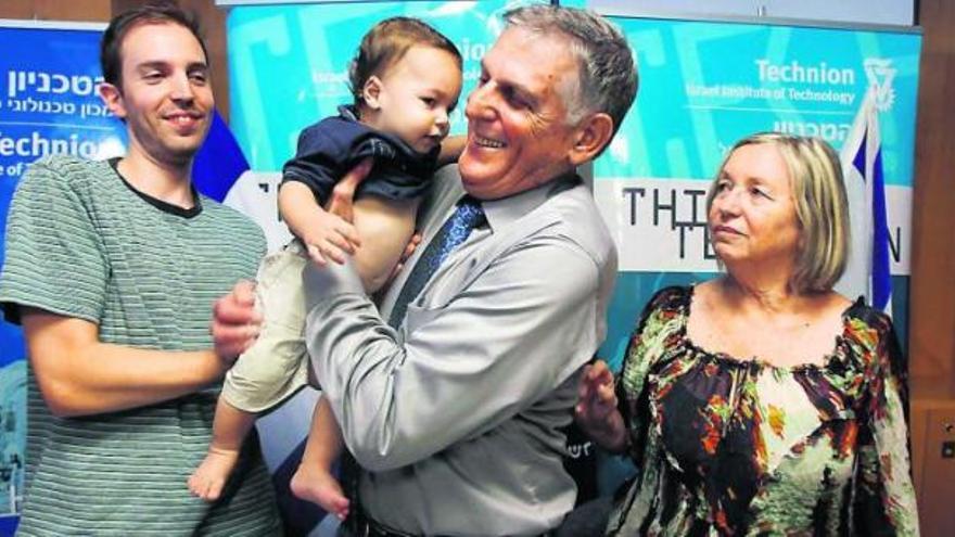 Daniel Shechtman sostiene en brazos a su nieto en presencia de su esposa y de su hijo, ayer, en el Instituto Israelí de Tecnología de Haifa.