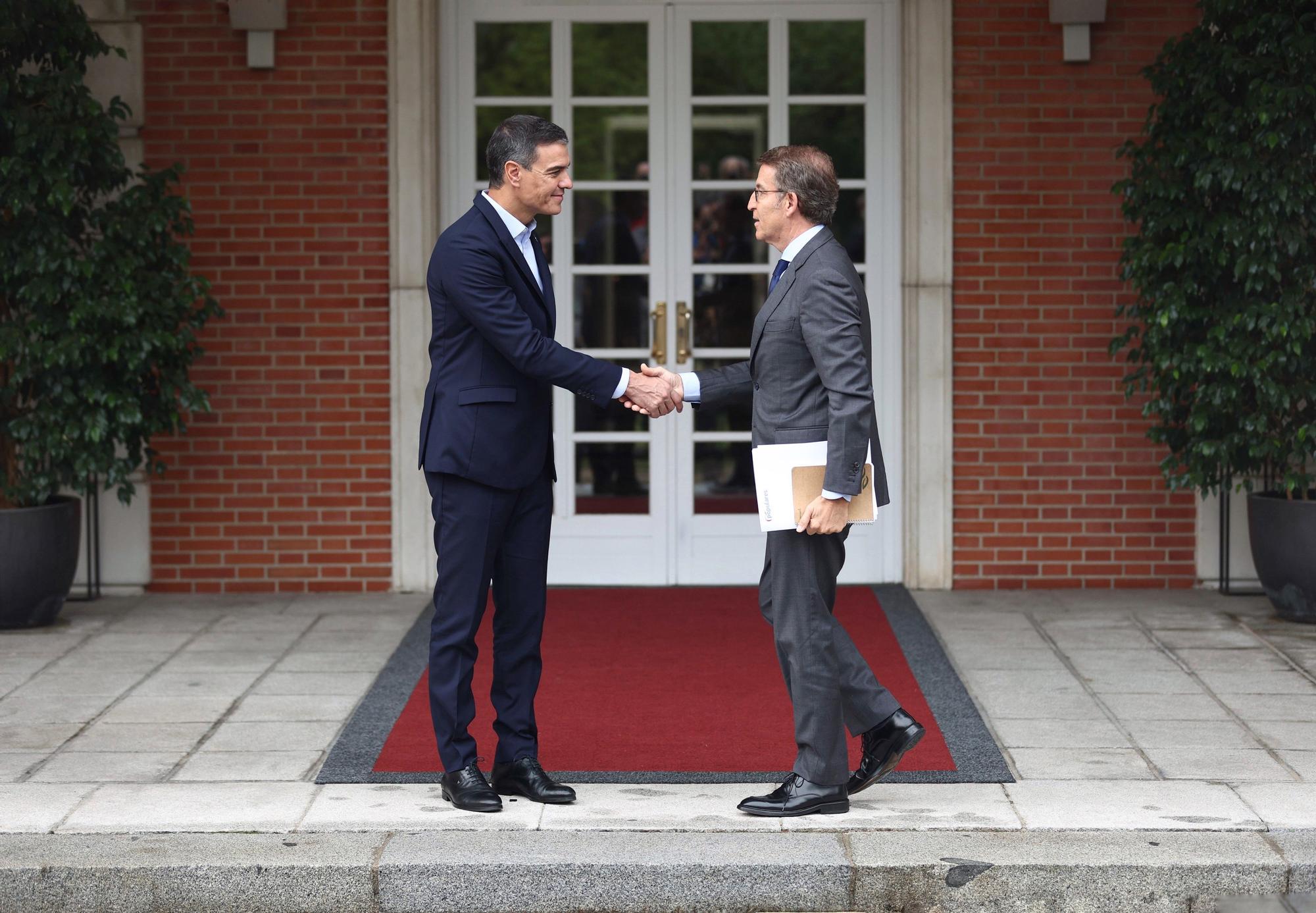 El presidente del Gobierno, Pedro Sánchez (i) y el presidente del Partido Popular, Alberto Núñez Feijóo (d), se saludan a su llegada a una reunión en La Moncloa, a 10 de octubre de 2022, en Madrid (España).