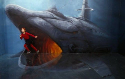 A girl runs past an art installation depicting a shark at the Museum of Optical Illusions in St. Petersburg