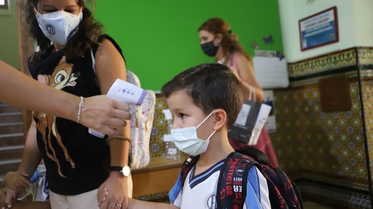 Toma de temperatura a un niño en un colegio.