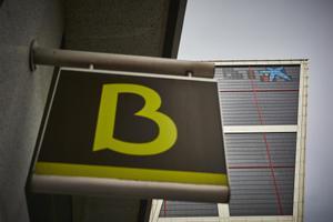 Archivo - Un cartel con el símbolo de Bankia delante del logo de Caixabank tras su sustitución por el de Bankia en las torres Kio, en Madrid (España).