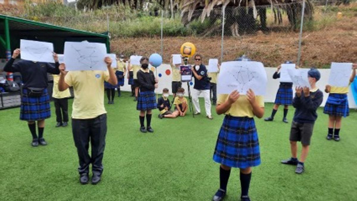 Itxiar Anguita junto a alumnado de Primaria preparando la simulación del recorrido aparente del Sol por las constelaciones zodiacales